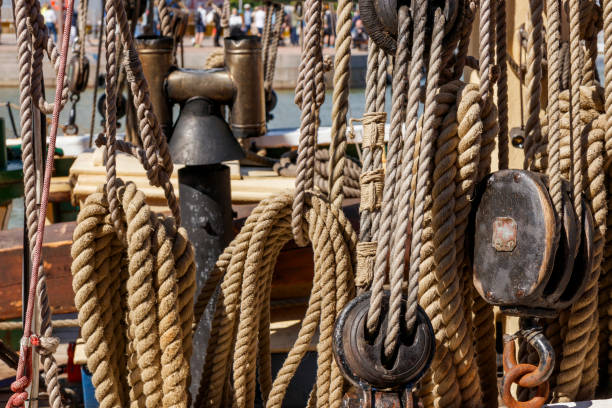 istock Sailing ship lines, pulleys and securing equipment tied down for the day. Deck and ropes, rigging on a wooden tall ship sail yacht. Close up view 2161592652