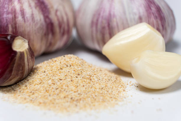 Ground dried garlic powder, natural spice, white background