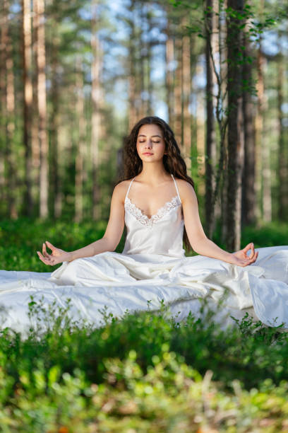 istock Young woman is sitting in the forest on a white bed 2161594620