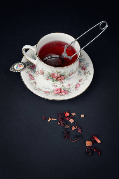 Still life with a beautiful fine china tea cup and tea accessories on a black background