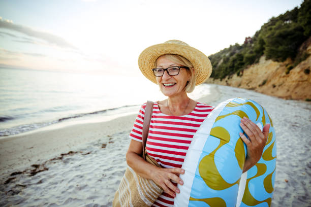 istock Mature woman enjoying day on a beach alone 2161595890