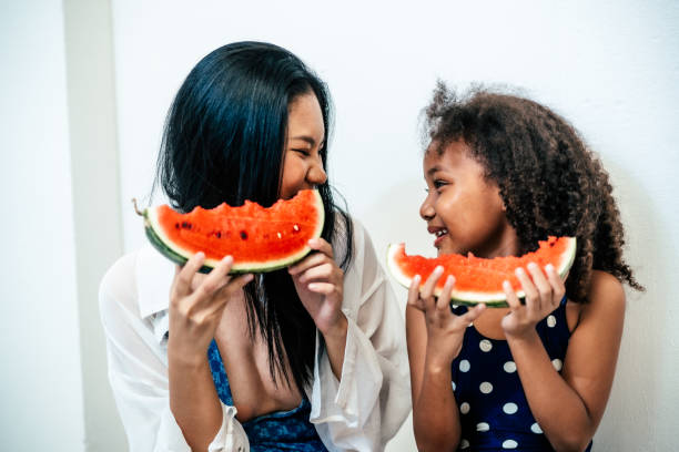 istock Mother and daughter eating watermelon 2161596282