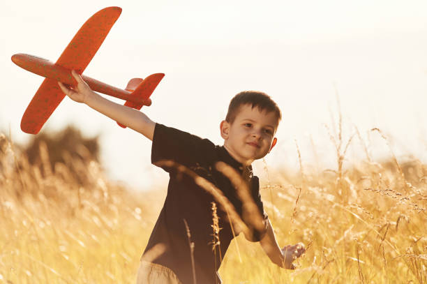 istock Red colored toy plane, playing. Little boy is having fun outdoors at summertime 2161596895