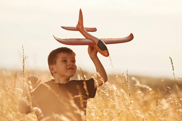 istock Holding red toy plane, playing. Little boy is having fun outdoors at summertime 2161596911