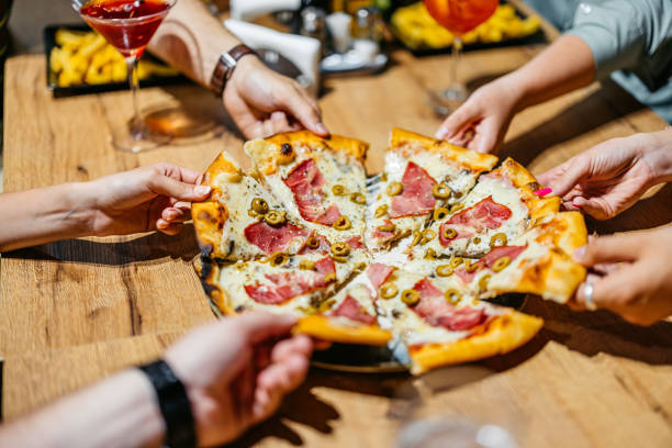 istock Six Young People Taking A Slice Of Pizza In A Pub 2161598156