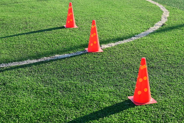 artificial green grass soccer field with orange training cones