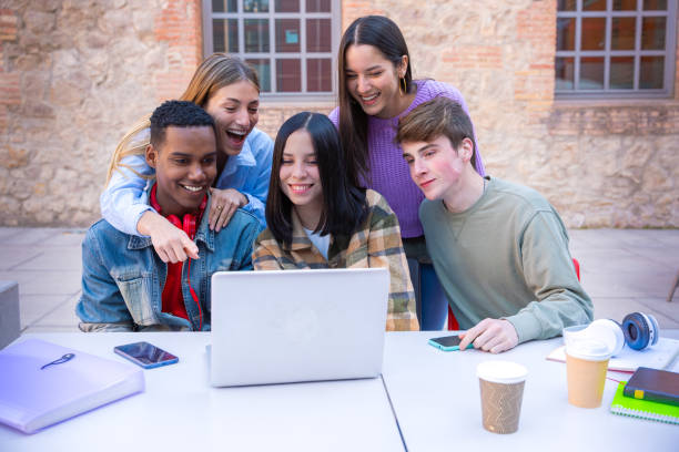 istock A group of students with laptops sit near the campus and communicate. 2161601636