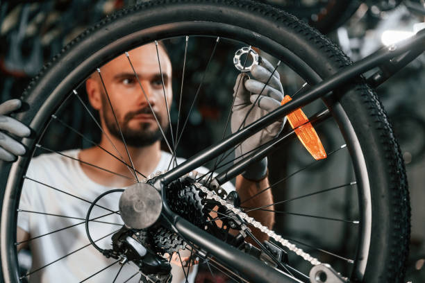 istock Spokes replacement. Repair man in bicycle shop, working in store 2161603559