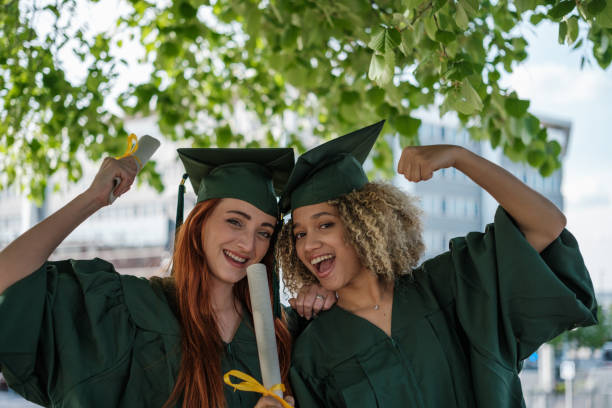 istock Two young students proud with their new university degree on graduation day. Concept: university career, success, title 2161604390