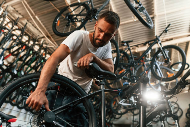 istock Final adjustments. Repair man in bicycle shop, working in store 2161604659