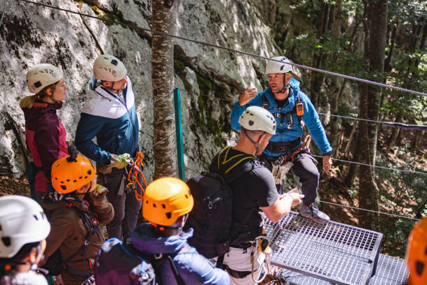 istock Group Receives Zipline Instructions in Forest Setting 2161605321