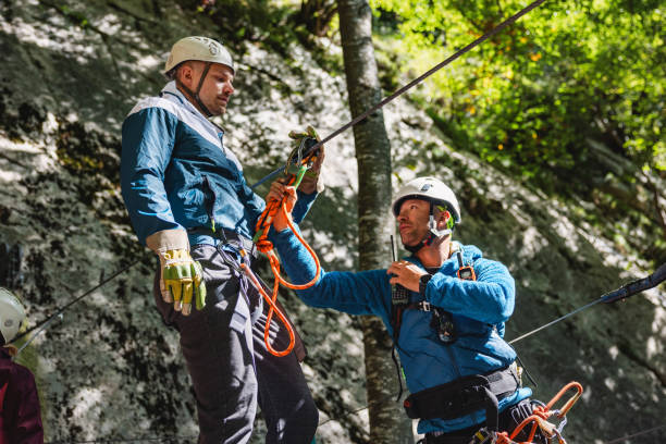 istock Zip Line Instructors Preparing Equipment in Forest 2161607214