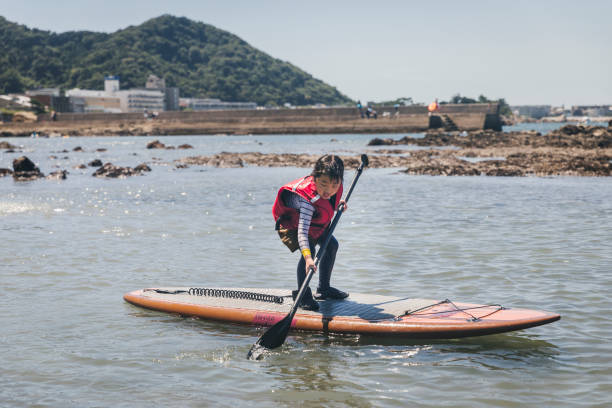 istock Asian girl playing standup paddle boarding 2161608009