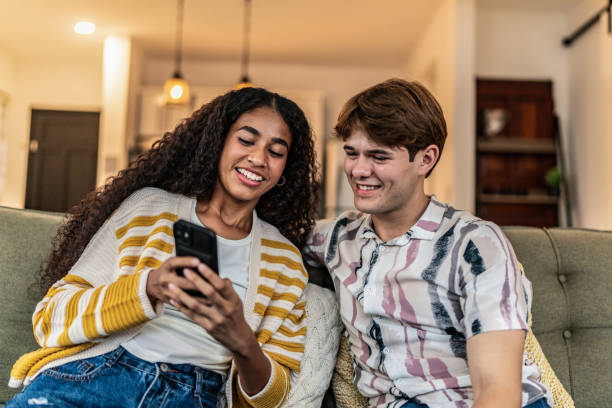 istock Friends talking and using mobile phone at home 2161609427