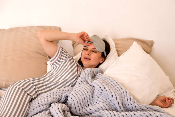 istock Woman waking up, adjusting eye mask in bed. 2161610009