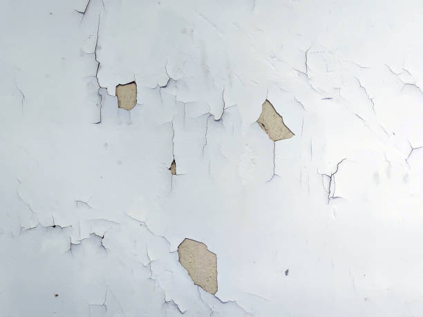 istock An old wall is severely damaged, with paint peeling off and several patches missing. 2161613052