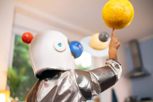istock Girl in a space suit playing at home, exploring and learning about planets, imagining space travel. 2161613101
