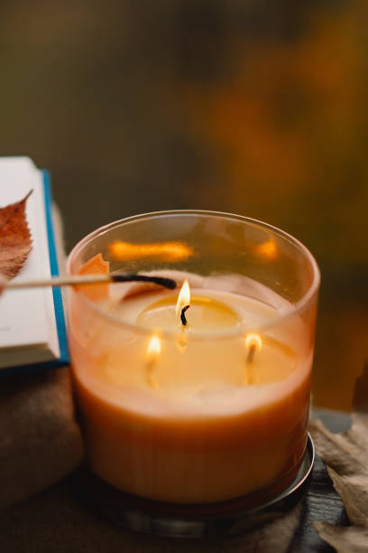 istock Hand with burning match lighting a candle on the windowsill 2161613123