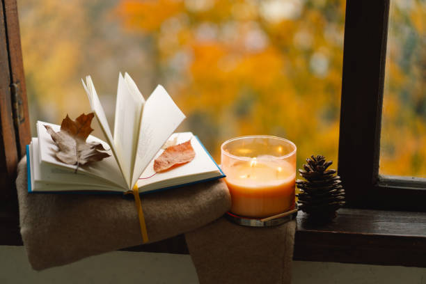 livre, pull, bougie et déco d’automne. - novembre photos et images de collection