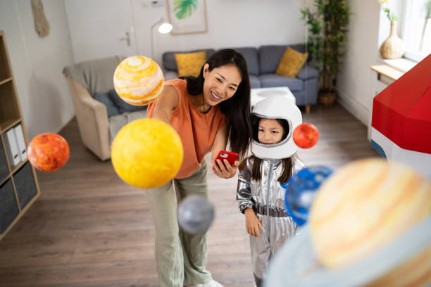 istock Mom and daughter e-learning about space over a mobile phone 2161614315