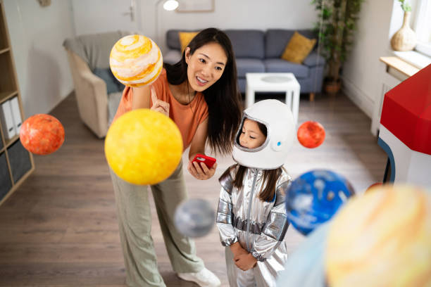 istock Mom and daughter e-learning about space over a mobile phone 2161614322