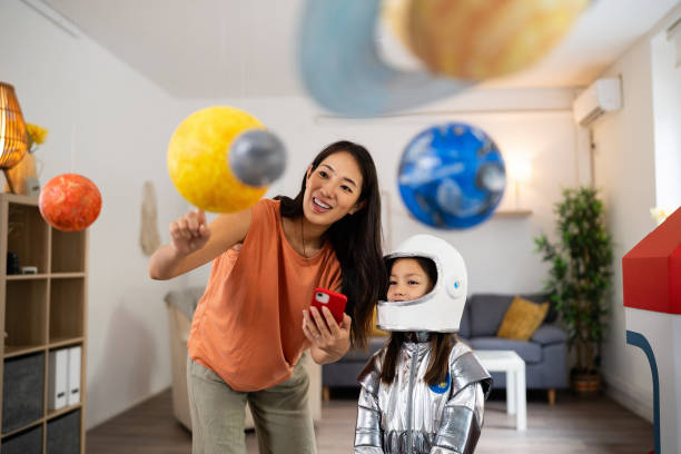 istock Mom and daughter e-learning about space over a mobile phone 2161614323