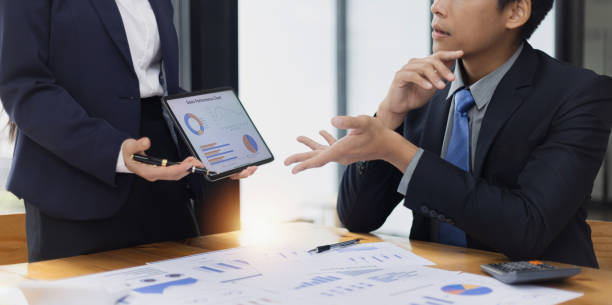 istock Two businessman and woman working with business data analytics on table at office. 2161615471