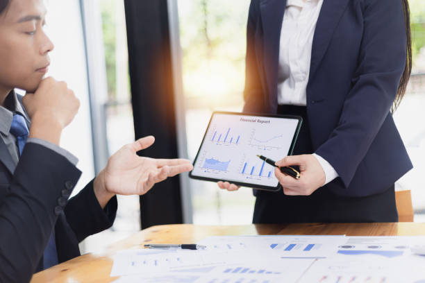 istock Two businessman and woman working with business data analytics on table at office. 2161615483