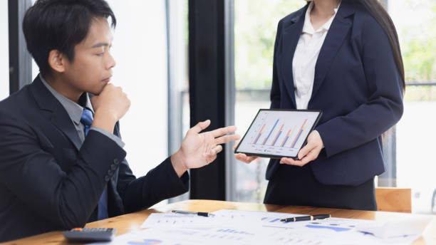 istock Two businessman and woman working with business data analytics on table at office. 2161615487