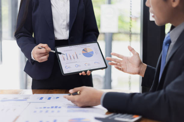 istock Two businessman and woman working with business data analytics on table at office. 2161615499