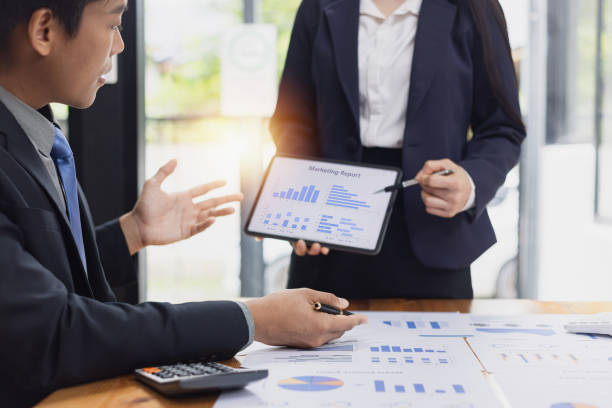istock Two businessman and woman working with business data analytics on table at office. 2161615500