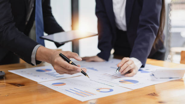 istock Two businessman and woman working with business data analytics on table at office. 2161615510