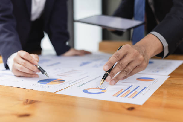 istock Two businessman and woman working with business data analytics on table at office. 2161615511