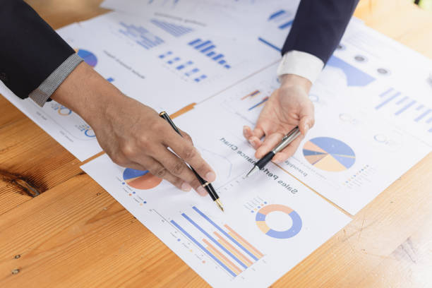 istock Two businessman and woman working with business data analytics on table at office. 2161615513