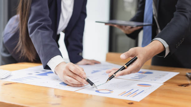 istock Two businessman and woman working with business data analytics on table at office. 2161615520