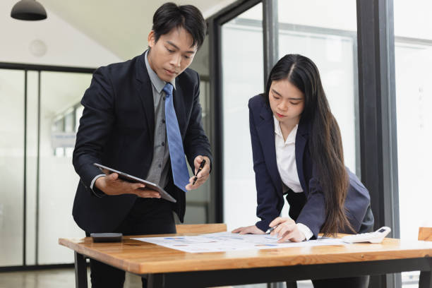 istock Two businessman and woman working with business data analytics on table at office. 2161615523