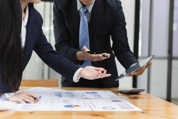 istock Two businessman and woman working with business data analytics on table at office. 2161615536