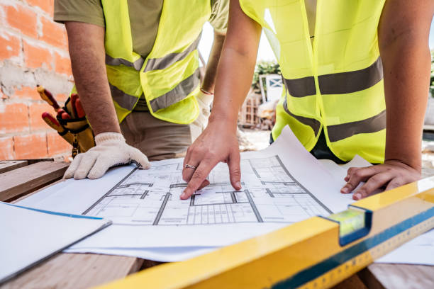 istock Close-up of a construction workers analyzing blueprint on construction site 2161616779