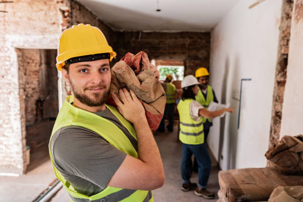 istock Portrait of a construction worker carrying a cement sack on a construction site 2161616884