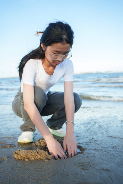 istock Asian girl playing on the beach 2161618640