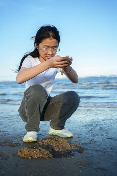 istock Asian girl playing on the beach 2161618644