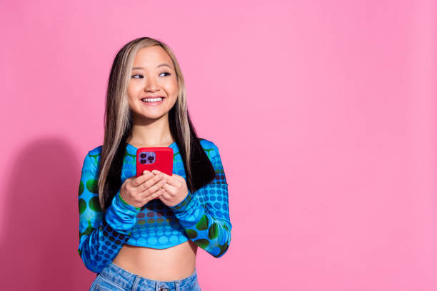 istock Photo of cheerful pretty lady dressed blue shirt texting modern device looking empty space isolated pink color background 2161621904