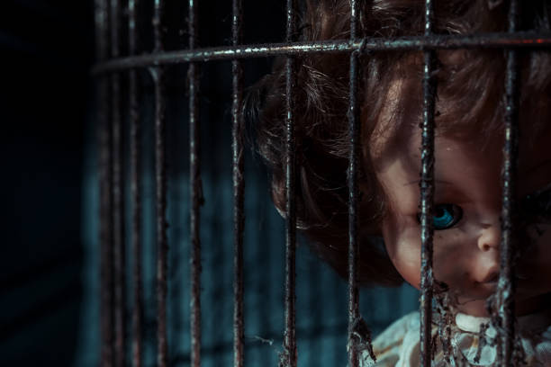 A close-up image of hands gripping vibrant orange bars symbolizes confinement and emotional struggle, evoking feelings of hope and despair in isolation.