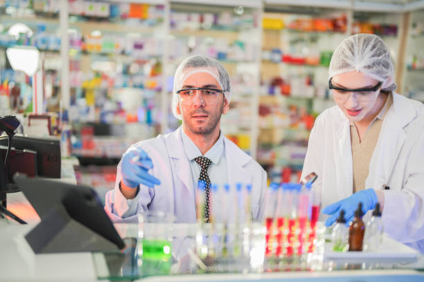istock scientists perform experiments and record data. people arranges equipment with test tubes and chemicals for producing medicine and biochemistry. man hold tubes of chemical liquids and plant samples. 2161626271