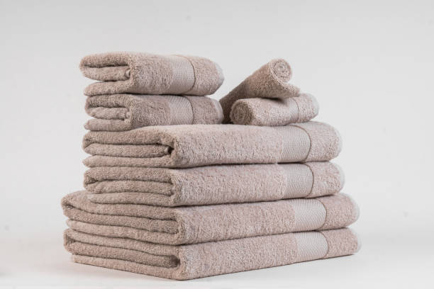 istock A stack of light brown folded towels on a white background. 2161627158