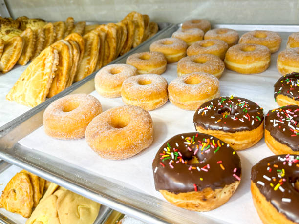 istock assorted donuts, including sugar-coated and chocolate-frosted varieties, along with other pastries 2161631099