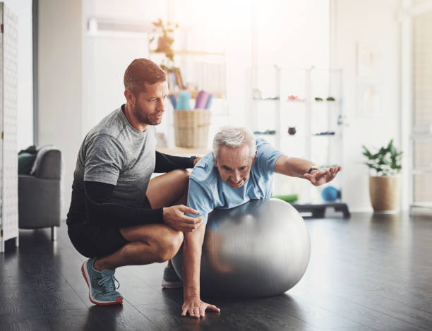 istock Stretching, elderly man and physiotherapist with ball for mobility training, support or muscle workout. Fitness, physiotherapy and senior person with exercise, development or healthcare in retirement 2161632244