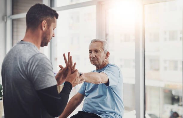 Physiotherapy, elderly man and hand with stretching for recovery, support and strength in retirement. Patient, care and people with muscle exercise for help, joint pain or rehabilitation in arthritis
