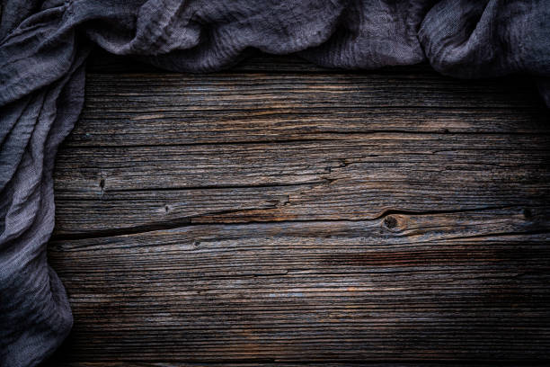 Flat lay of an empty rustic wooden table with crumpled tablecloth at the border