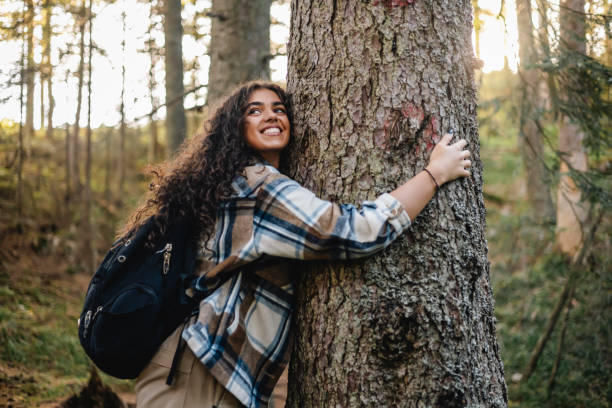 istock Woman hugging tree during forest hike, smiling 2161634781
